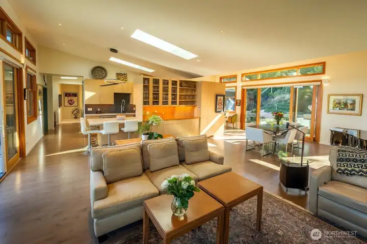 The living/dining area, looking toward the kitchen, in morning light.