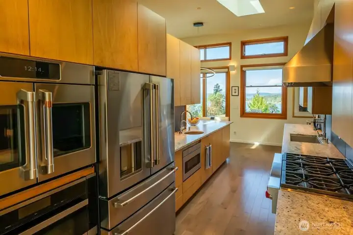 Chef's kitchen with Wolf range, two Miele dishwashers, Miele steam/convection oven with built-in water supply, Cafe french door oven, an extra large Cafe refrigerator, drawer microwave, prep sink, instant hot water, and large pantry.