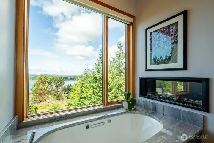 Primary suite bathroom: heated Kohler tub and gas fireplace.