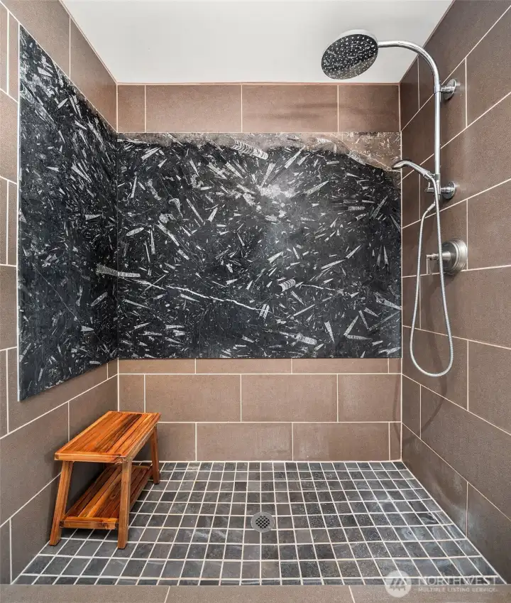 Primary walk-in shower with double swinging glass doors.