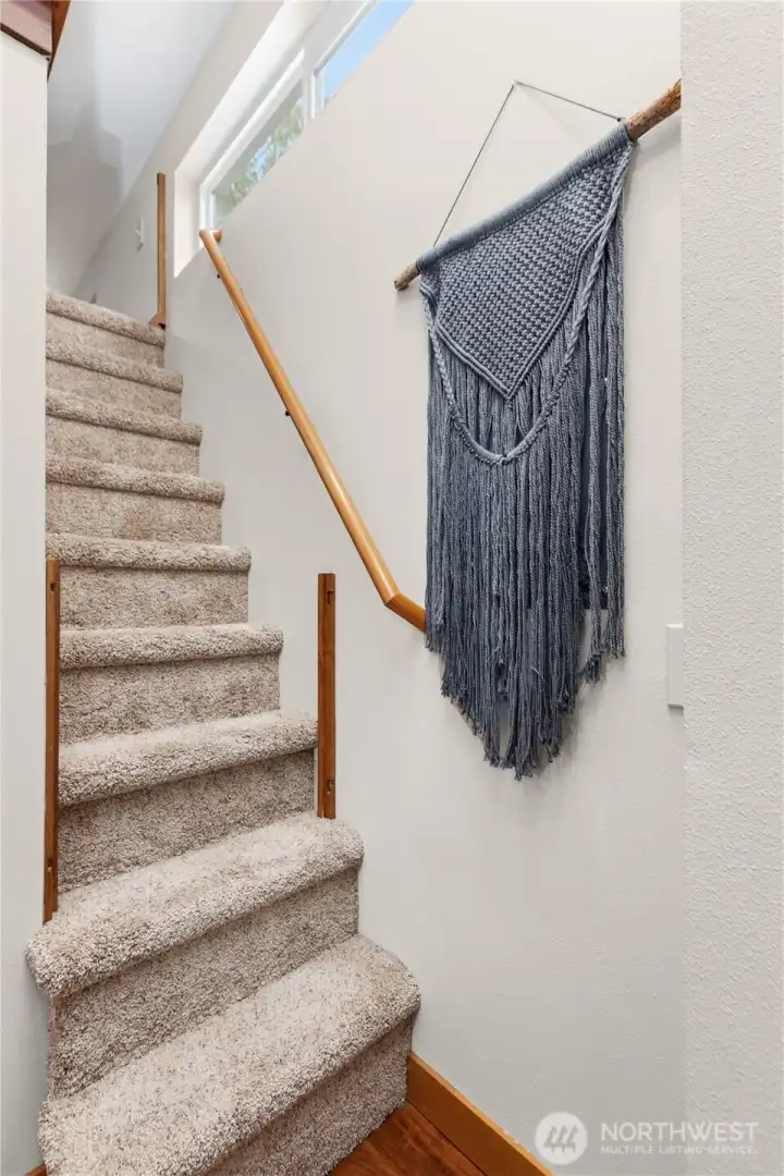 Interior staircase leading to the upper loft area with additional sleeping or flex space. Interior staircase leading to the upper loft area with additional sleeping or flex space.