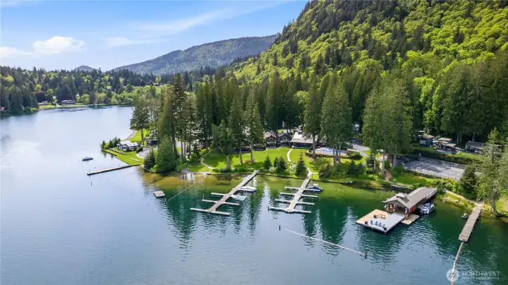 Contemporary cottage-style homes are positioned within a well-maintained waterfront setting surrounded by trees and lake views. Contemporary cottage-style homes are positioned within a well-maintained waterfront setting surrounded by trees and lake views.
