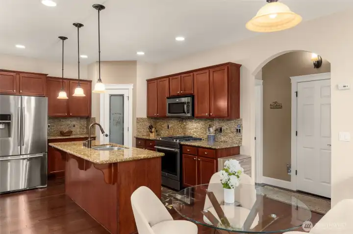 Spacious kitchen with a new gas range, updated stainless steel appliances and granite countertops.