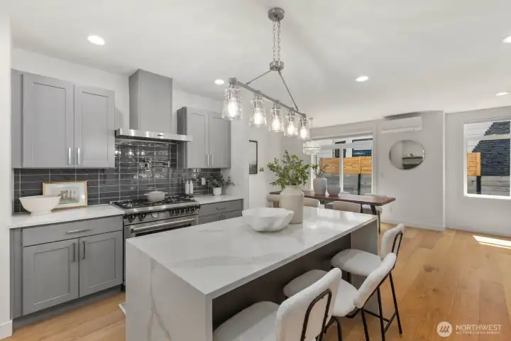 Chef’s kitchen with waterfall island seating, Bertazzoni range, and abundant workspace. Chef’s kitchen with waterfall island seating, Bertazzoni range, and abundant workspace.