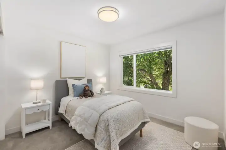 Bright secondary bedroom with a large window and leafy outlook. Bright secondary bedroom with a large window and leafy outlook.
