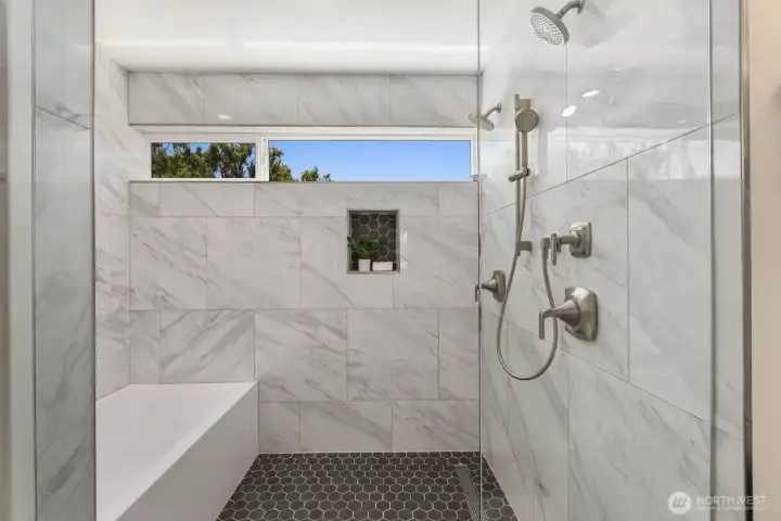 Oversized tiled shower with dual shower heads and an adjacent soaking tub. Oversized tiled shower with dual shower heads and an adjacent soaking tub.