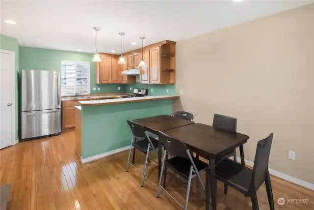 Open kitchen and dining layout with pendant lighting, modern appliances, and plenty of counter space.