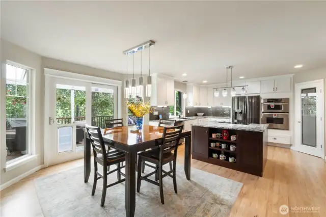 Dining Area & Kitchen – Open concept layout with access to outdoor deck; island-centric kitchen.
