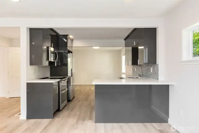 Kitchen with bar and almost new stainless appliances is bold and sleek.