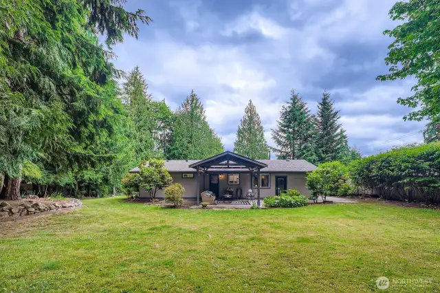 A large backyard with mature trees and beautiful landscaping