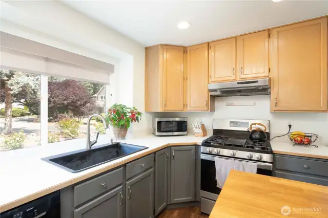 Countertops are off-white Formica with a wood-look trim, and an extended 42” deep counter at the sink area beneath a 5.9’ wide window.