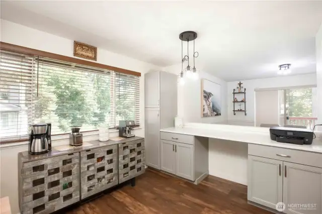 Pass-through counter to the dining room. Includes a tall grey pantry cabinet with 2 doors, 2 drawers, and double-door lower cabinets. Coffee bar not included.