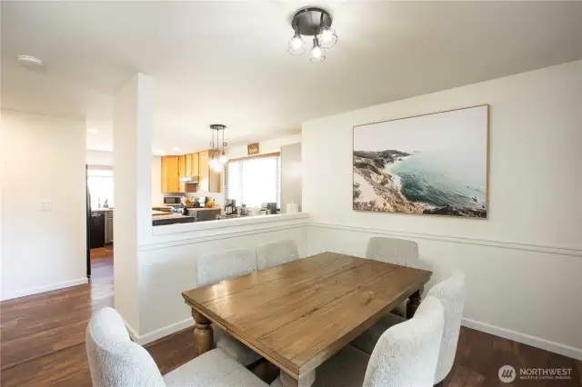 Dining area features decorative rail trim and a half wall (3’4” high x 7’2” wide) dividing it from the kitchen. Includes a built-in PetSafe dog door (10”W x 16”H) and sliding glass door to deck with vertical 3-panel fabric shades.