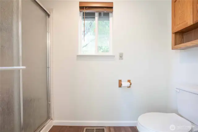 Primary Bathroom -separate enclosed space for shower and toilet with its own window, accessed by a pocket door.