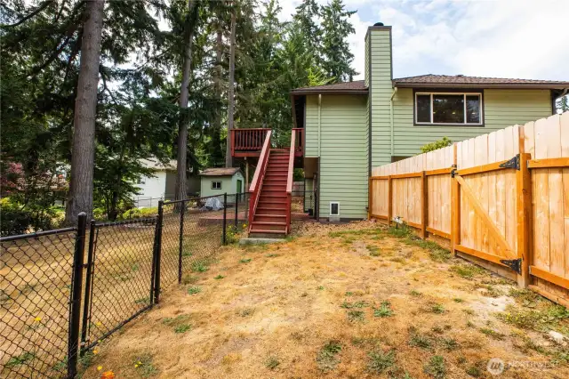 View of the main level deck overlooks the fully fenced yard on the left side.