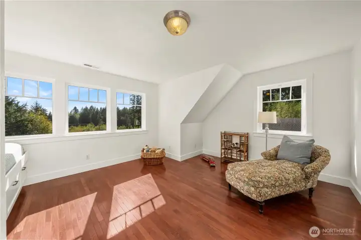This cozy bedroom features abundant windows, dark wood floors, a built-in bunkbed...definitely reminiscent of a coastal cottage.