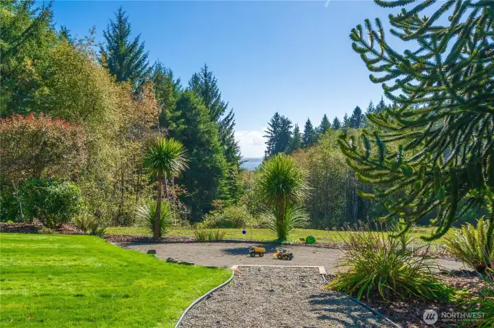 Looking down the property features a sand playground full of fun and beyond to the water.