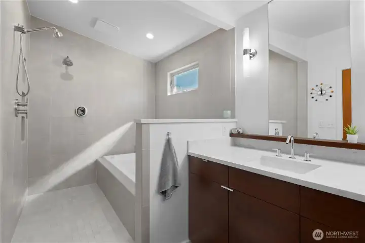 The primary bathroom has a sleek wet room with jetted tub and spa-like shower