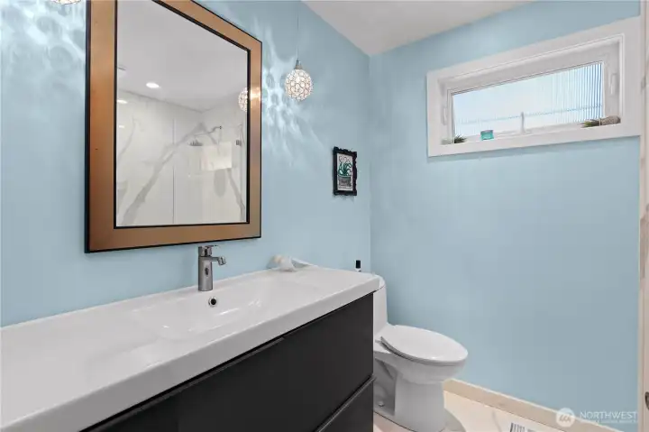 Second bathroom on the main level. It features low maintenance sinter stone walk-in shower and flooring