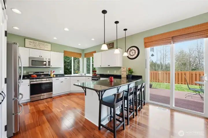 Large, open kitchen with granite counters, stainless steel appliances and Koa wood floors.
