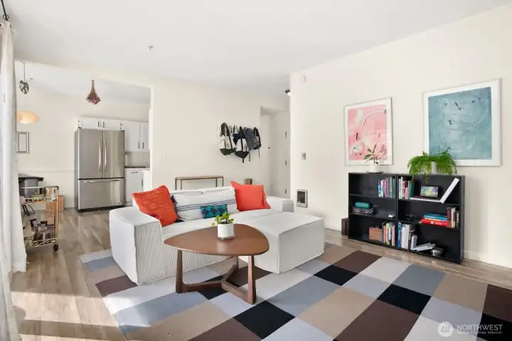 Open-concept living area connecting to kitchen and entryway