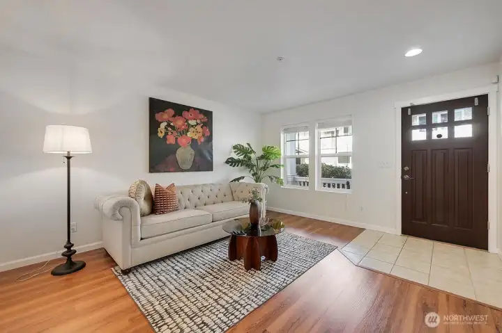 Bright and welcoming entry-level flex space offers fresh interior paint, warm natural light, and a clean, modern aesthetic. The open layout easily functions as a living area, home office, or multi-purpose retreat, featuring updated flooring, a stylish seating arrangement, and a seamless flow from the tiled entry into the main living zone. Thoughtful décor and a neutral palette create an inviting first impression the moment you step inside.