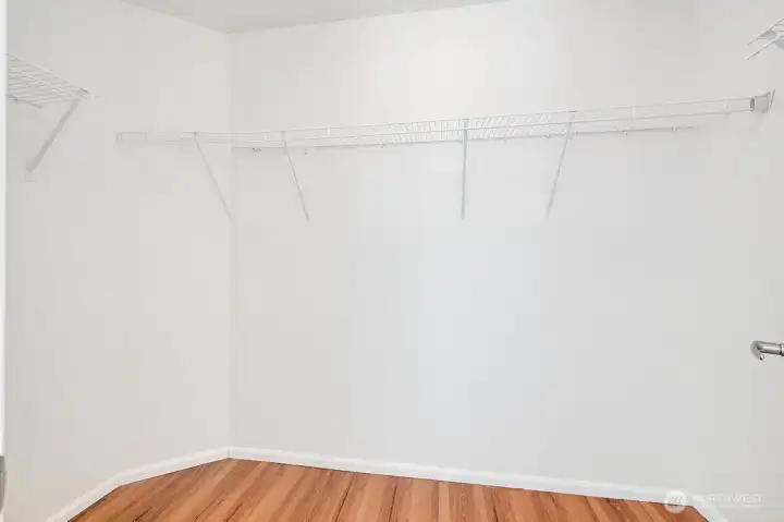 Primary suite includes a spacious walk-in closet with ample shelving and open storage, offering a clean and organized layout for effortless wardrobe management. Bright, well-lit, and thoughtfully designed, this closet provides generous room for clothing, accessories, and everyday essentials—an ideal extension of the primary retreat.