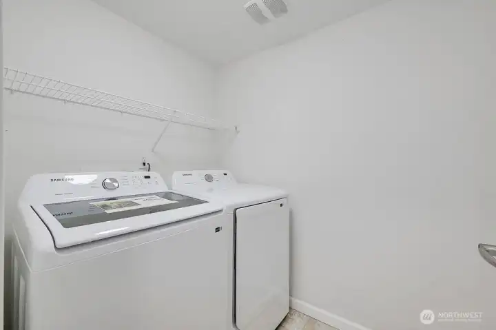 The lower level includes a spacious laundry room equipped with a brand-new washer and dryer that stay with the home. This functional space offers plenty of room for organization and everyday convenience, making household tasks simple and efficient.