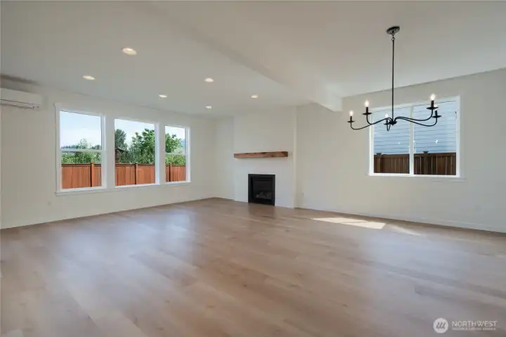 Great room with gas fireplace and wood mantle that is open to the dining room & kitchen.  Pics are of a different 2601 Hattie plan home. Features and colors may differ.