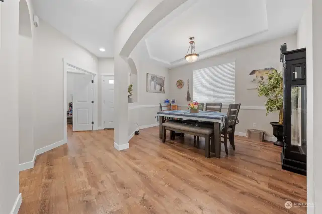 Impressive formal dining room with arched entry and crown molding.
