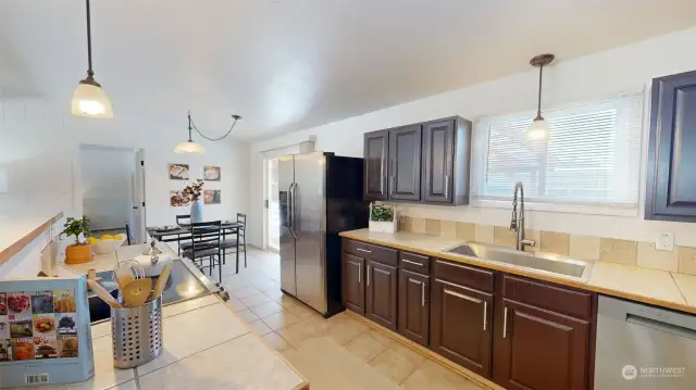 The spacious kitchen offers ample cabinet & counter space, large single basin sink, and window looking out to the backyard.