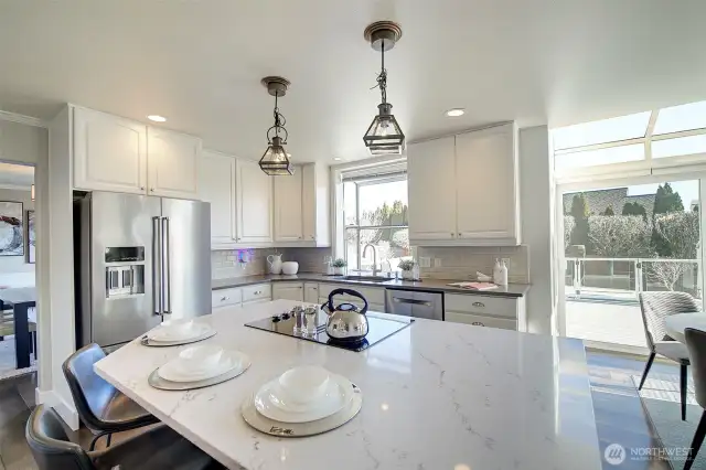 Beautiful white cabinetry, quartz countertops and tile backsplash beautifully accent this area of the home.