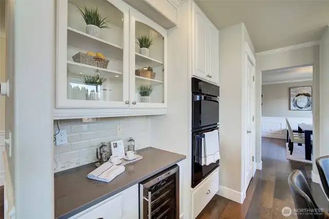 Glass front cabinets are perfect for showing off your collectables. A wine refrigerator is also featured here!