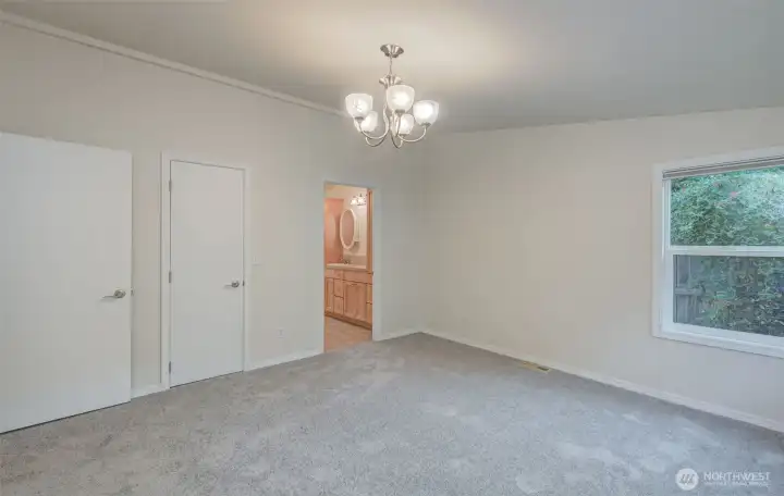 Primary bedroom looking toward the walk-in closet and primary bathroom.