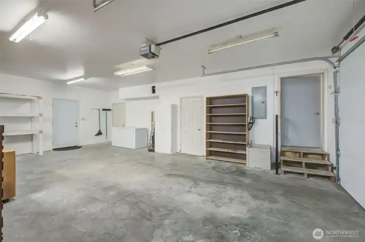 In the shop and looking (from left to right) towards the back door, the steps leading upstairs to the bonus room, the 1/2 bath with laundry room and the door into the home.