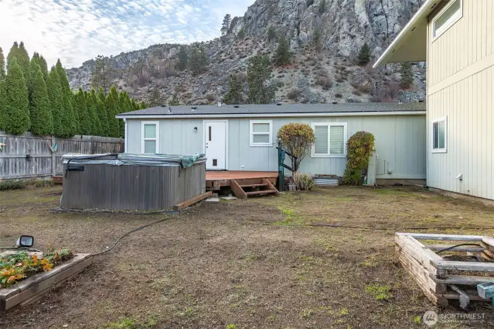 Back of home. The hot tub is working, but needs a new cover. It can also be removed.