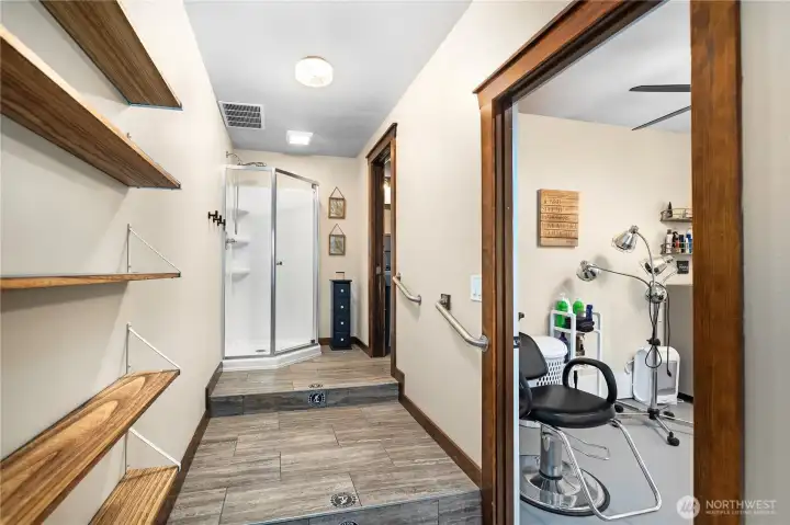 View leading from open-concept living space into hallway. Flex room with additional exterior access to the right, shower toward the rear, and separate bathroom to the far right.
