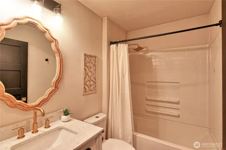 Full bath in hallway off kitchen and bedrooms.