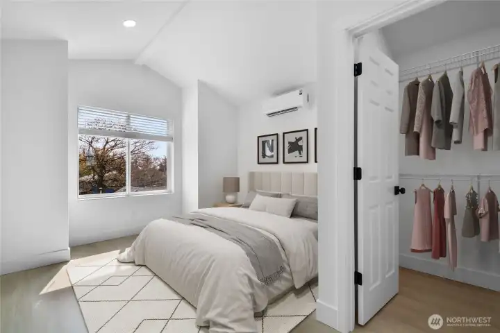 Primary bedroom with vaulted ceilings and a walk in closet.