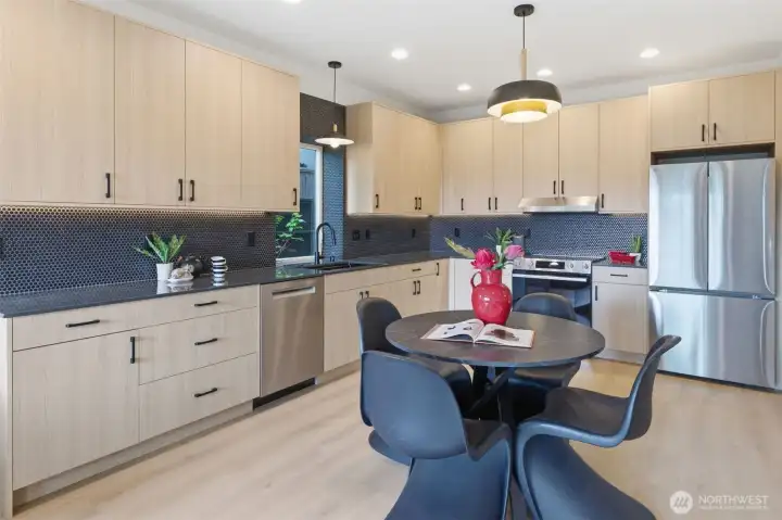 Designer kitchen with quartz counters, custom cabinetry, stainless steel appliances, tile backsplash, and abundant storage.
