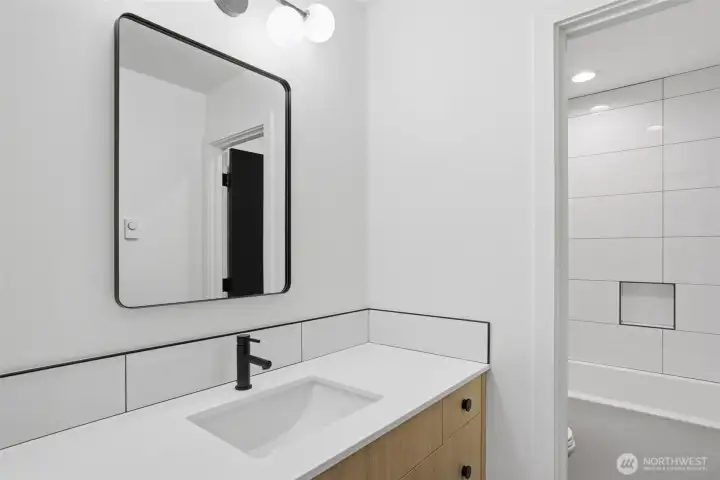 Shared full bath with deep soaking tub on second level.