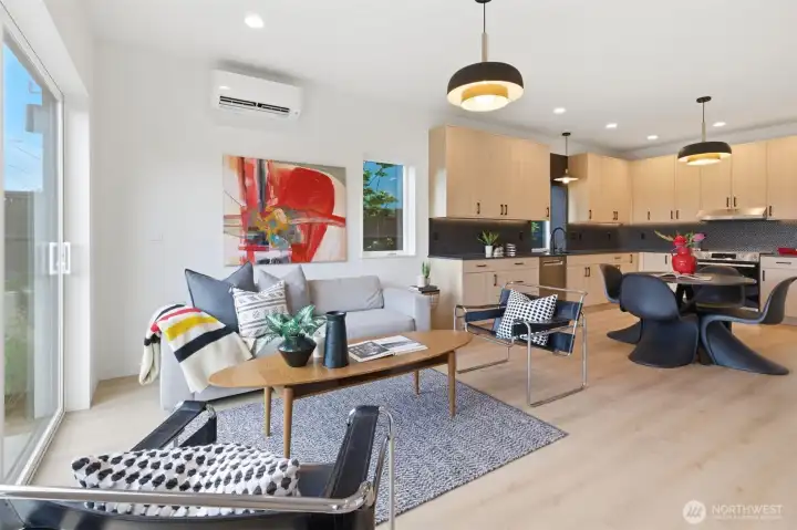 Bright open-concept living room with large sliding doors, natural light, mini-split heating and cooling, and seamless indoor-outdoor flow.