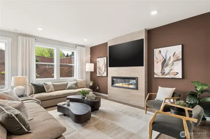 Open plan living spaces with tiled feature electric fireplace wall.