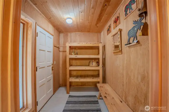Entry mudroom for removing shoes doubles as a pantry space.