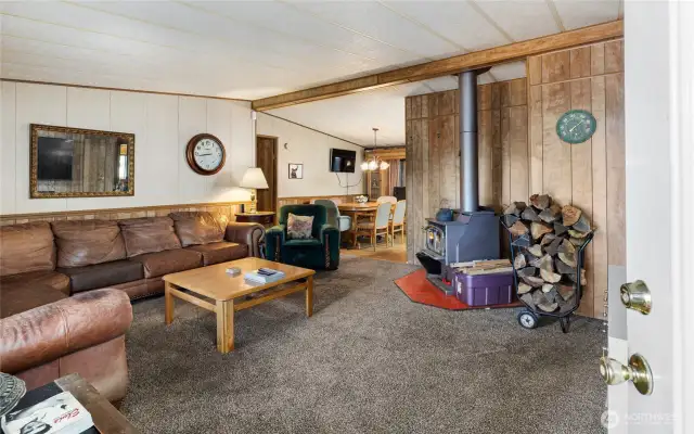 Living room with a wood burning fireplace overlooking the dining room.