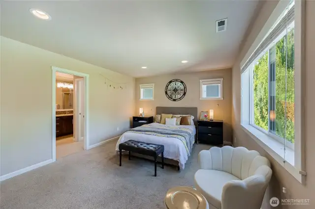 Double French doors welcome you into the spacious master bedroom with views of garden and greenery to the back of the house.
