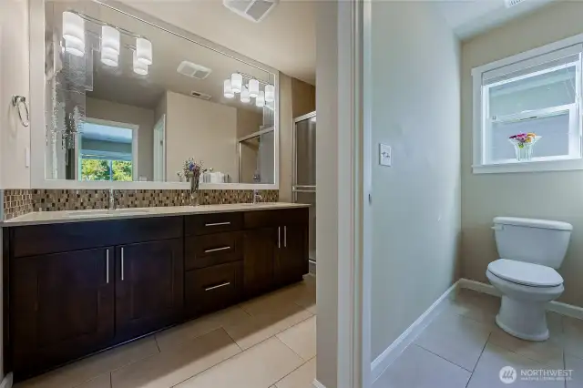 Master bath is an ensuite with separate water closet, double vanity, walk-in closet, walk-in shower. Tiled floors and shower, mosaic backsplash, quartz countertop, soft close cabinetry.