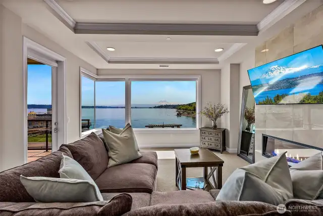 A lovely living room with colorful electric fireplace, windows galore and a door out to your very private deck.  Also, the views!