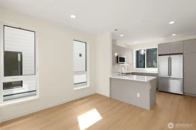 Photos of model home with similar finishes & floor plan.Modern kitchen layout with peninsula seating, sleek cabinetry, and stainless steel accents.