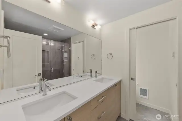 Photos of model home with similar finishes & floor plan. Full bath with double vanity, quartz counters, and elegant wall lighting.